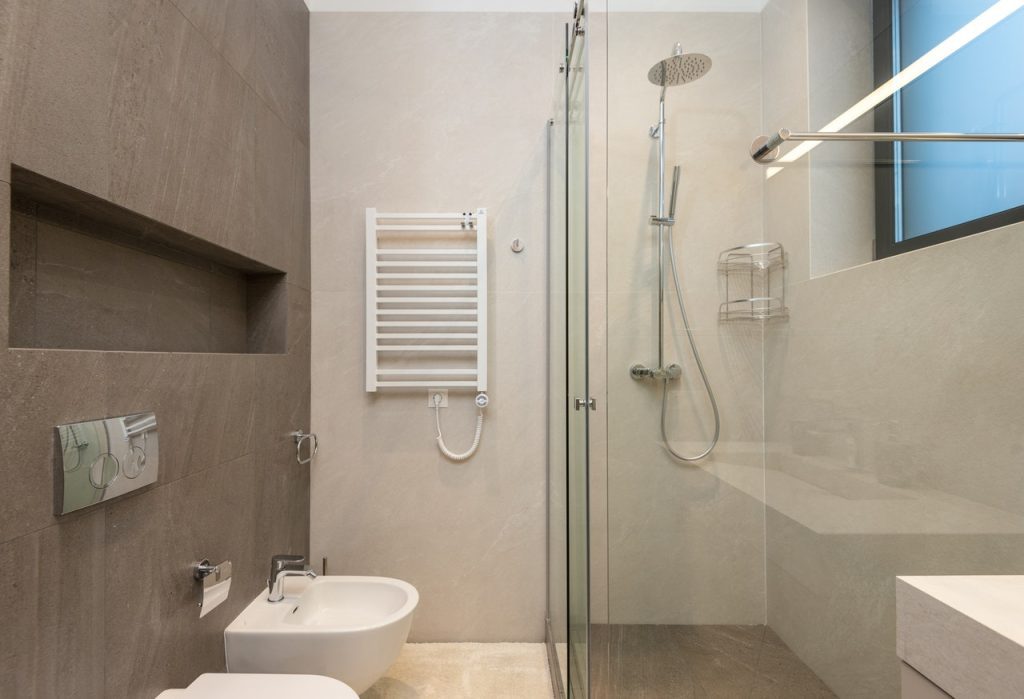 Ceramic bidet and shower cabin in contemporary bathroom